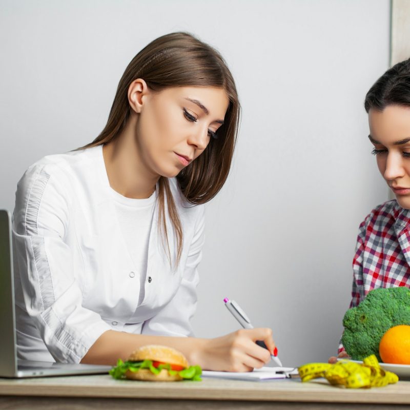 Young woman visiting nutritionist in weight loss clinic Young woman visiting nutritionist in weight loss clinic