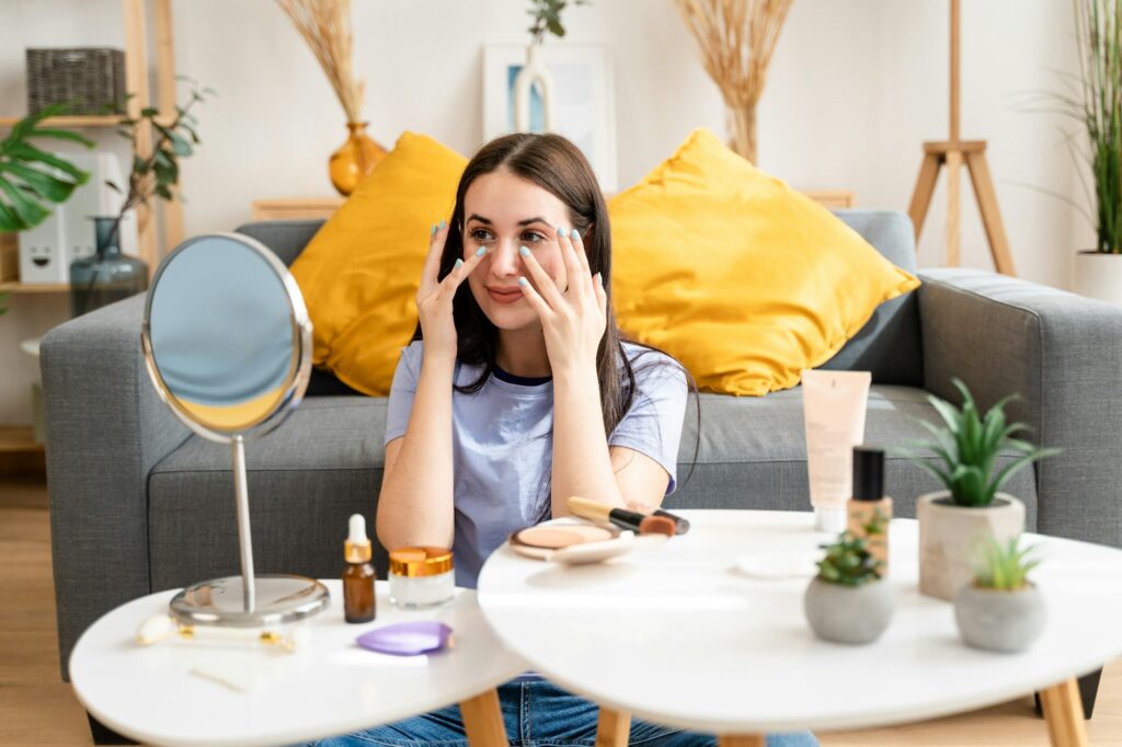 Young woman in living room doing facial beauty routine.